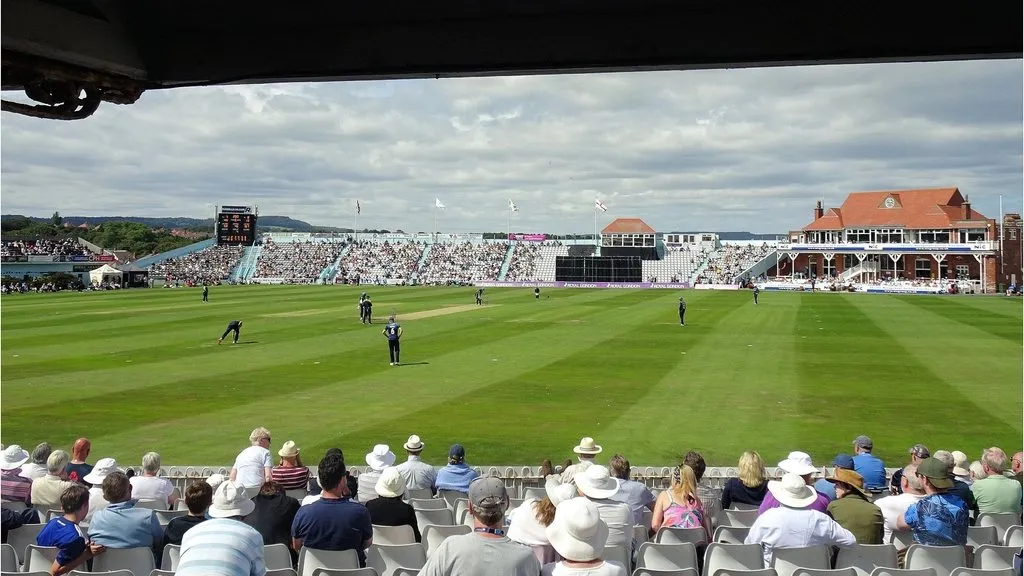 Spectators watching a cricket match from the stands